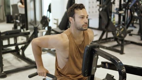 man in gym on machine exercising