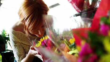 Beautiful-female-florist-smelling-flowers