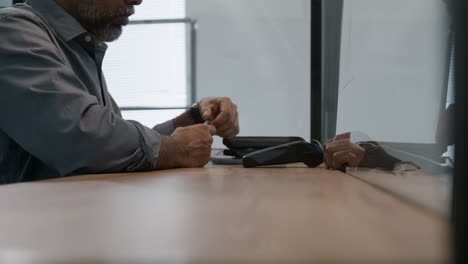 man paying with credit card at office