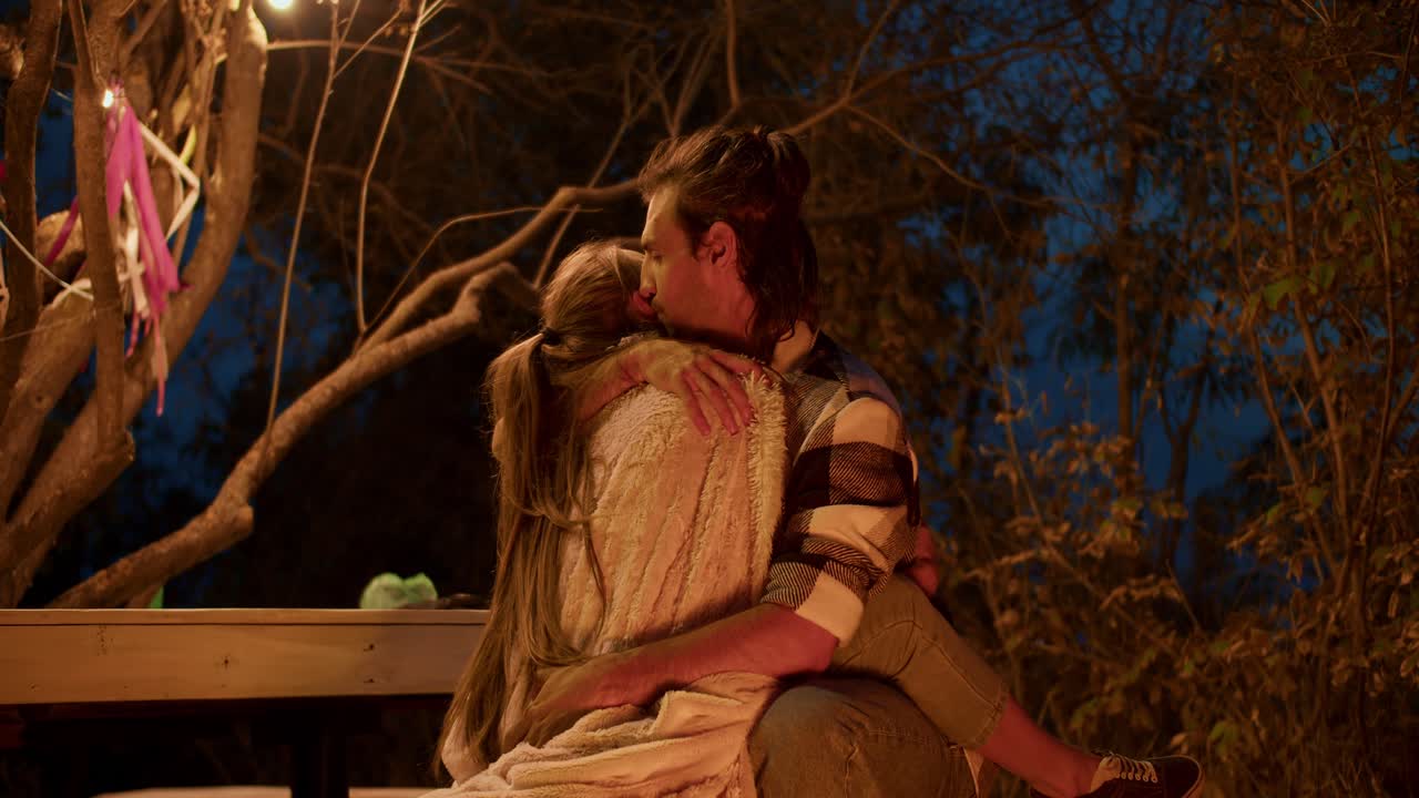 사랑에 빠진 커플이 안고 있습니다. 도시 밖의 저녁 레크리에이션. 시골 집에서 휴식을 취합니다.
