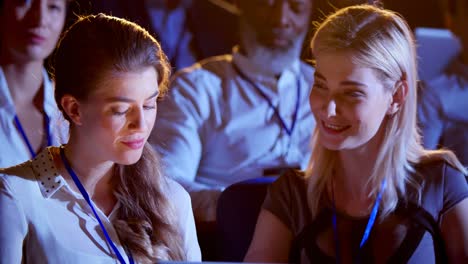 caucasian businesswomen working on laptop during seminar in auditorium 4k