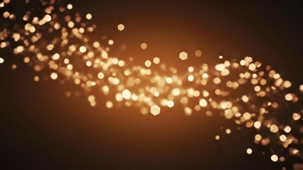 Abstract video of golden bokeh lights with a soft focus, angled slightly from above
