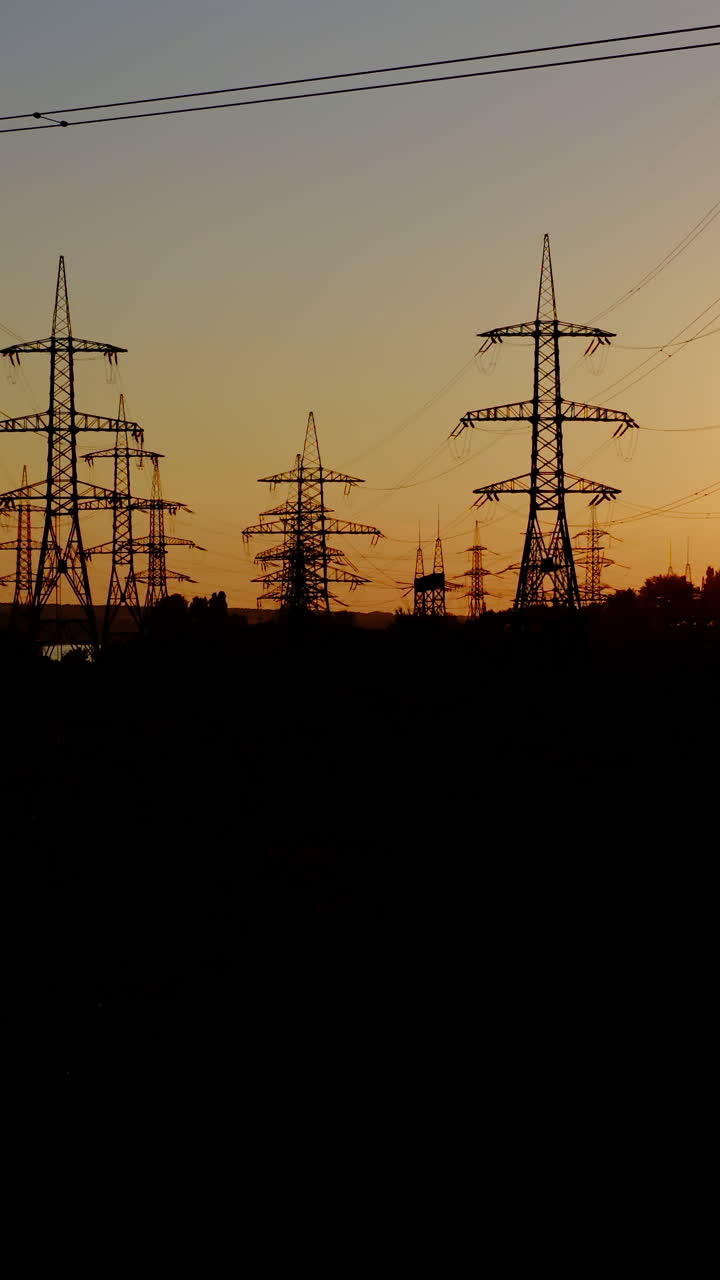 High voltage post at sunset. High voltage towers with electrical wires. Vertical video