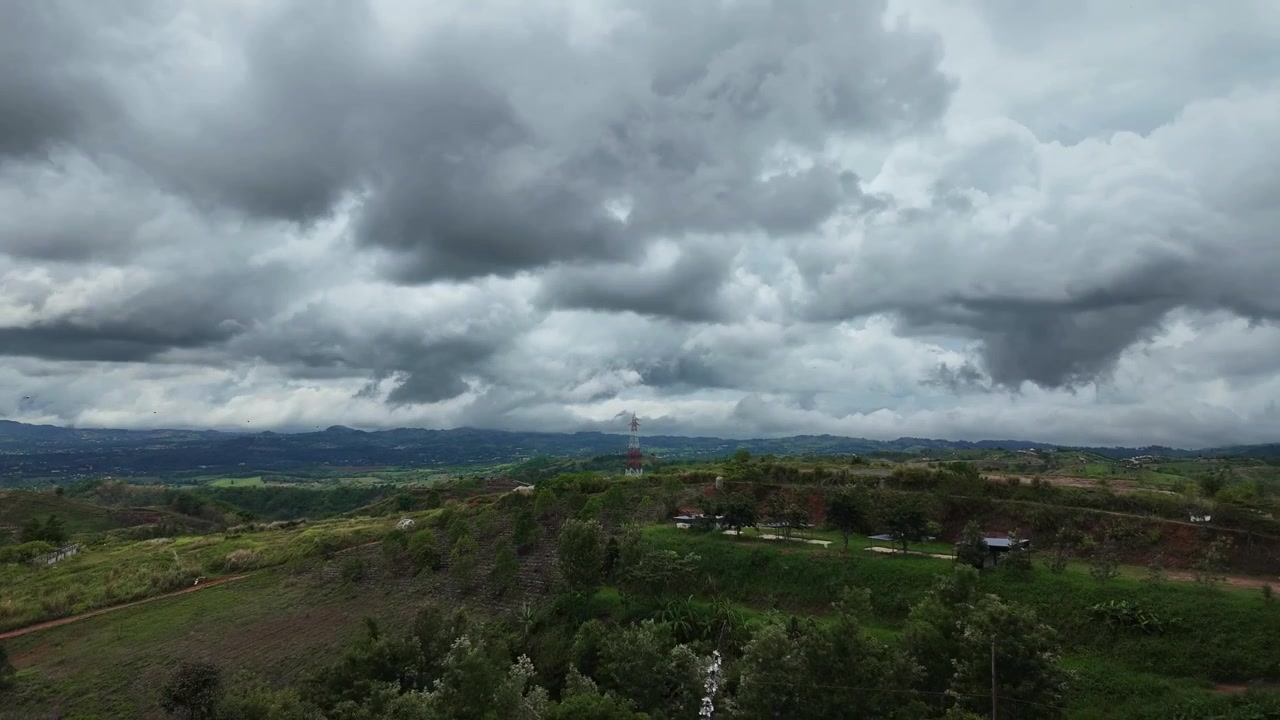 Drammatico timelapse panoramico di pesanti nuvole temporalesche grigie e nebbia bassa che si muovono rapidamente su dolci colline e valli lussureggianti e verdi a Phetchabun, Thailandia. Splendida vista panoramica di paesaggio tropicale