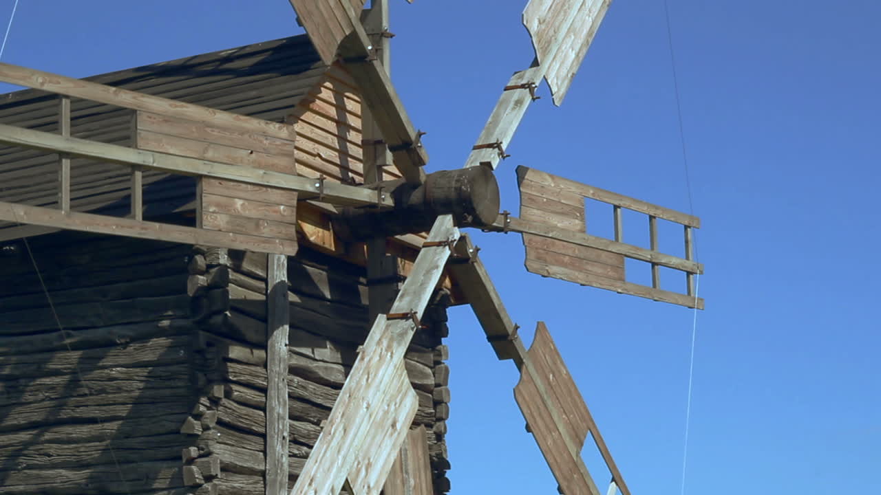 старые лопатки ветряной мельницы, вращающиеся на ветре. энергия ветра и традиционное строительство мельницы