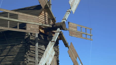 old windmill blades rotating on wind. wind power and traditional mill building