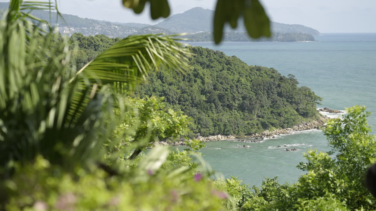impresionante vista de la montaña y el mar a través de árboles tropicales en la isla de phuket, tailandia