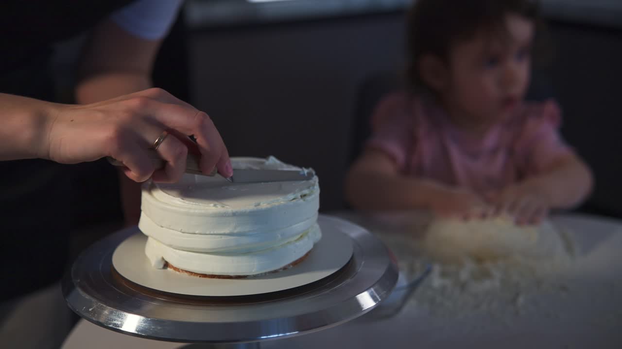 Mani che decorano una torta con glassa bianca in una cucina di casa