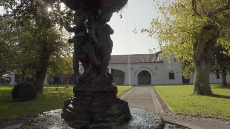 Font-of-angels-with-water,-sun-rays-and-main-arch-of-the-Undurraga-vineyard,-Talagante,-Chile