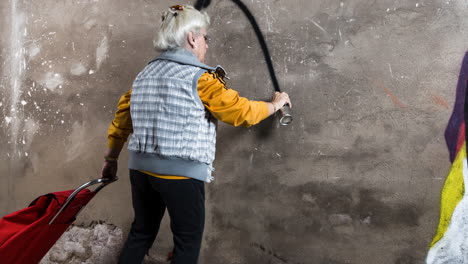 rebel grandma graffiti artist against an urban wall