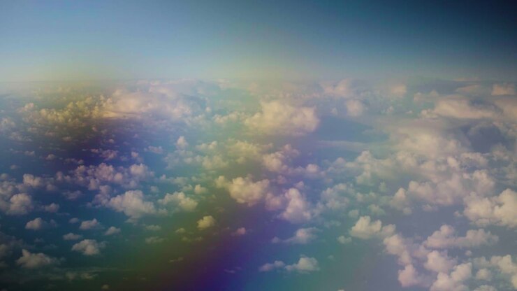 Clouds view from plane over the sea with rainbow effect