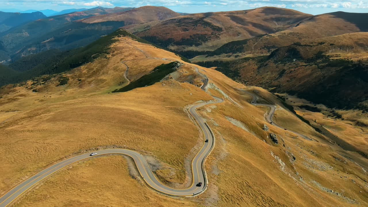 Aerial drone view of nature in Romania. Carpathian mountains, sparse vegetation, Transalpina road with cars