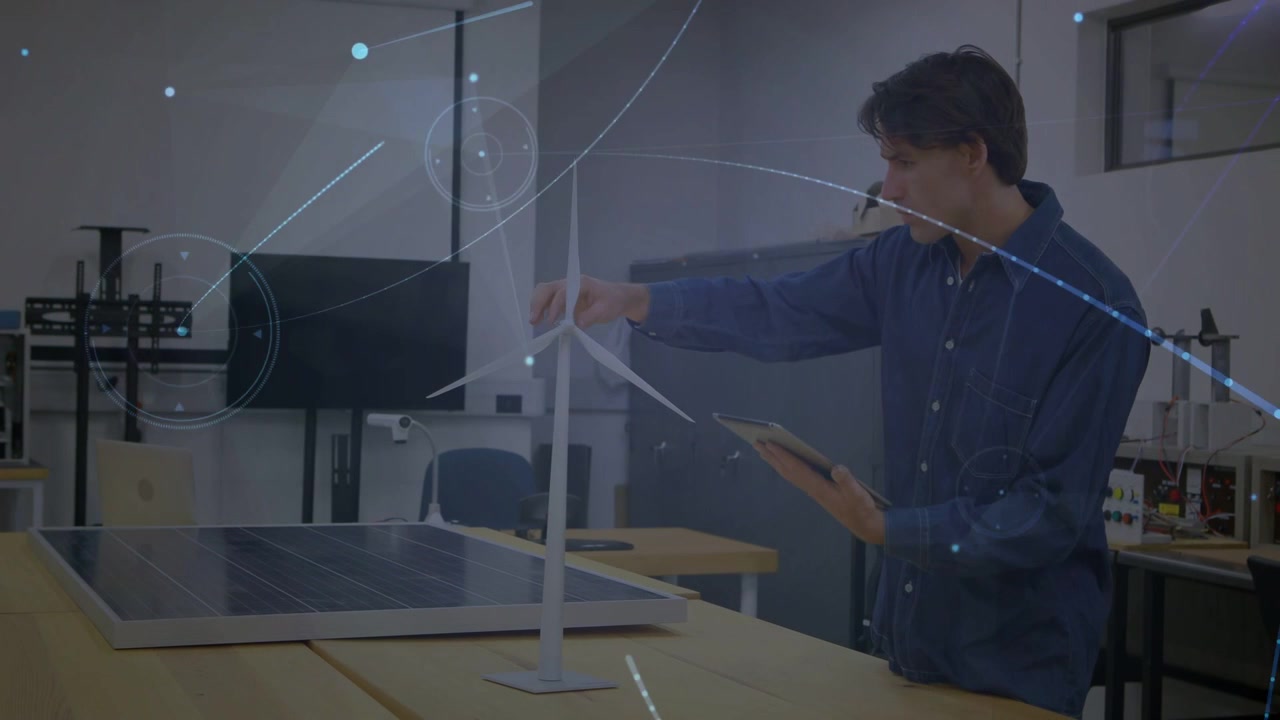 Male engineer tapping tablet in engineering lab, showing overlays while adjusting turbine, testing