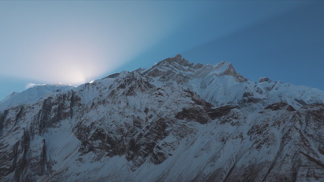 amanecer temprano de la cordillera de annapurna, nepal, el dron revela el pico brillante, el cielo azul, la nieve, y una increíble toma de lapso de tiempo, aventura turística de montañismo 4k