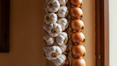 a charming display of garlic and onions: exploring the rustic beauty of ingredients hanging in a kitchen atmosphere for culinary enthusiasts and food lovers