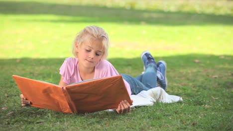 Niña-Leyendo-Un-Libro-Sobre-La-Hierba