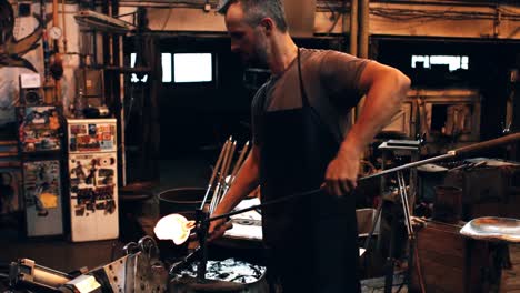 glassblower forming and shaping a molten glass