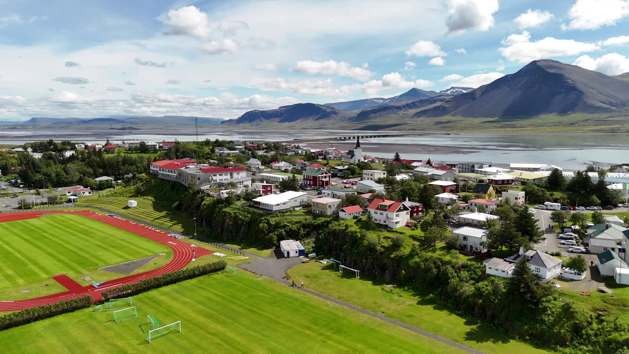 Aerial view of Borgarnes town center in Vesturland, showing streets, buildings, and surrounding landscape under sunny clear skies