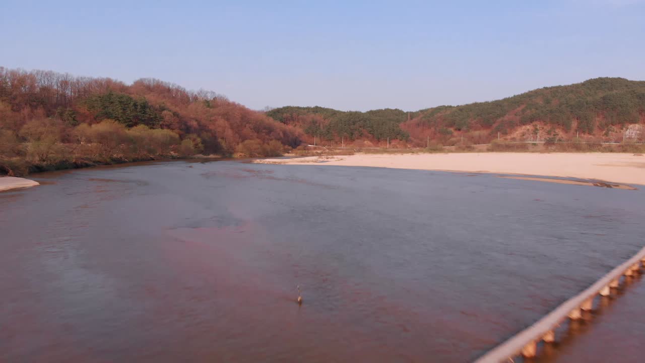 Aerial low altitude takeover of tiny wooden bridge above the river