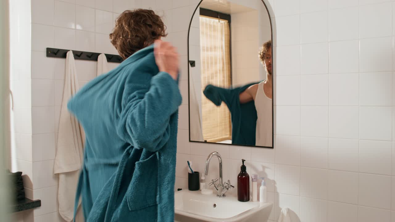 Uomo che si veste con un accappatoio in bagno