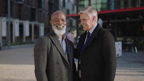 portrait of mature successful businessmen smiling happy in city enjoying partnership