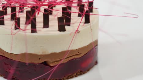 elegante postre de varias capas con decoraciones rosadas