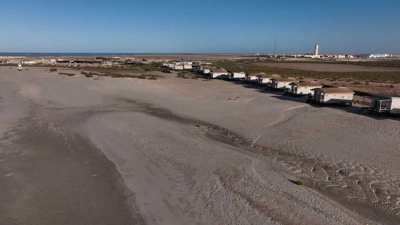Ampia vista aerea con drone di campi desertici costieri vicino alla spiaggia atlantica a Dakhla, Marocco, ideale per progetti di turismo, viaggi e avventura.