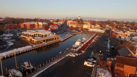 Volando-A-Través-De-Gaviotas-Moviéndose-Hacia-El-Centro-De-La-Calle-Principal-De-Annapolis-Y-El-Edificio-De-La-Capital-Del-Estado-De-Maryland-Durante-El-Amanecer-De-Invierno