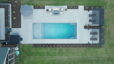 luxurious fiberglass pool in residential backyard surrounded by landscaping