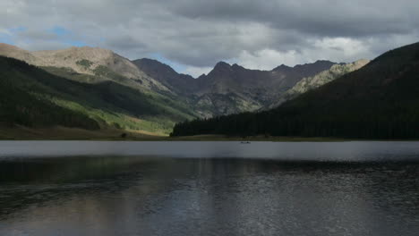 Aerial-cinematic-drone-Piney-Lake-Ranch-people-canoe-canoeing-Vail-Beaver-Creek-Avon-Colorado-Gore-Range-mountain-landscape-late-summer-afternoon-rain-clouds-stunning-peaceful-calm-forward-motion