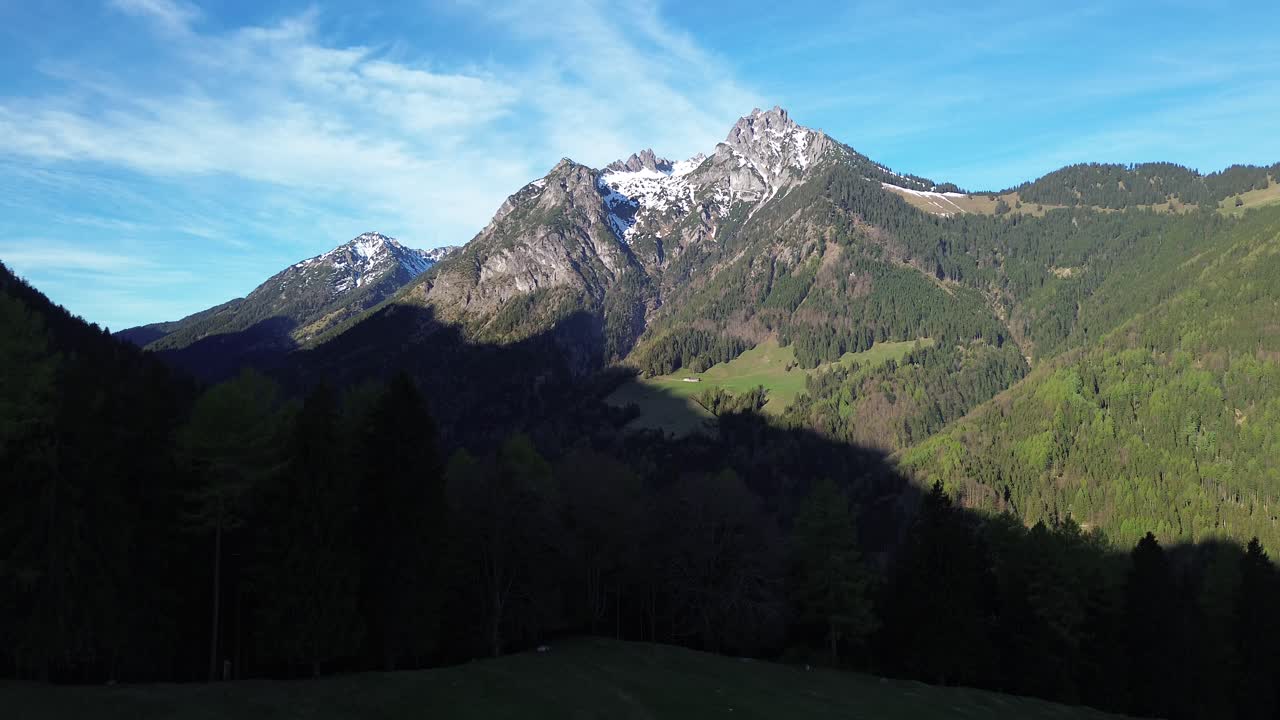 검은색 재을 입은 사람이 정상 에 드론을 날려 산의 풍경과 함께 을 가로지르며 오스트리아, 유럽의 은 날에 눈 인 정상과 함께