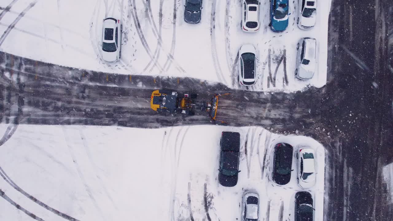 tractor de arado de nieve limpiando la calle durante las nevadas, vista aérea de arriba hacia abajo