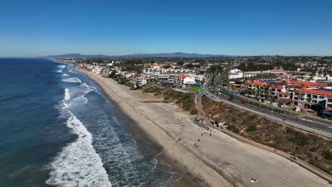 Drohnenaufnahme-Von-Rechts-Nach-Links-Von-Carlsbad,-Kalifornien,-Usa-Am-Strand-Und-Blick-Auf-Eine-Bergkette-Im-Hintergrund-An-Einem-Hellen-Sonnigen-Morgen