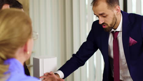 Arquitecto-Caucásico-En-Traje-De-Negocios-Explicando-Su-Plan-Al-Equipo-De-Inversores