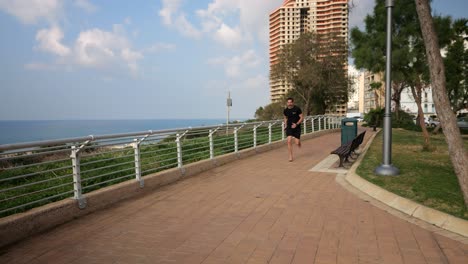 Male-runner-in-black-sportswear-and-barefoot-exercising