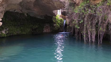 Beautiful-woman-take-bath-in-cavern-full-of-water-idyllic-landscape-called-"Salto-del-Usero"-in-Bullas,-Spain