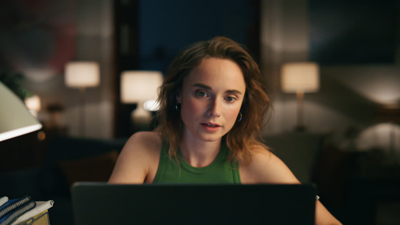 freelancer tranquilo hablando llamadas de video en casa de cerca. chica seria escribiendo notas