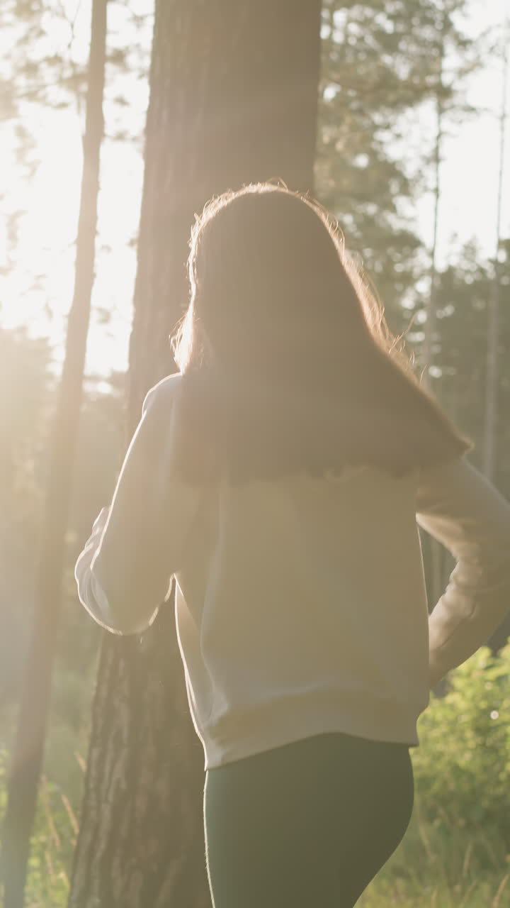 la corredora disfruta de correr en la naturaleza. la mujer corre por la noche pasando por los árboles bajo la cálida luz del sol participando en ejercicios de fitness para mejorar la forma del cuerpo