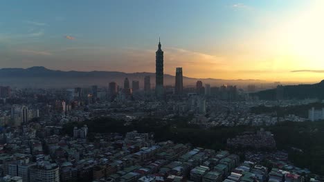 epic aerial over tapei city skyline with silhouette of tower 101 during epic blue hour and golden sunrise