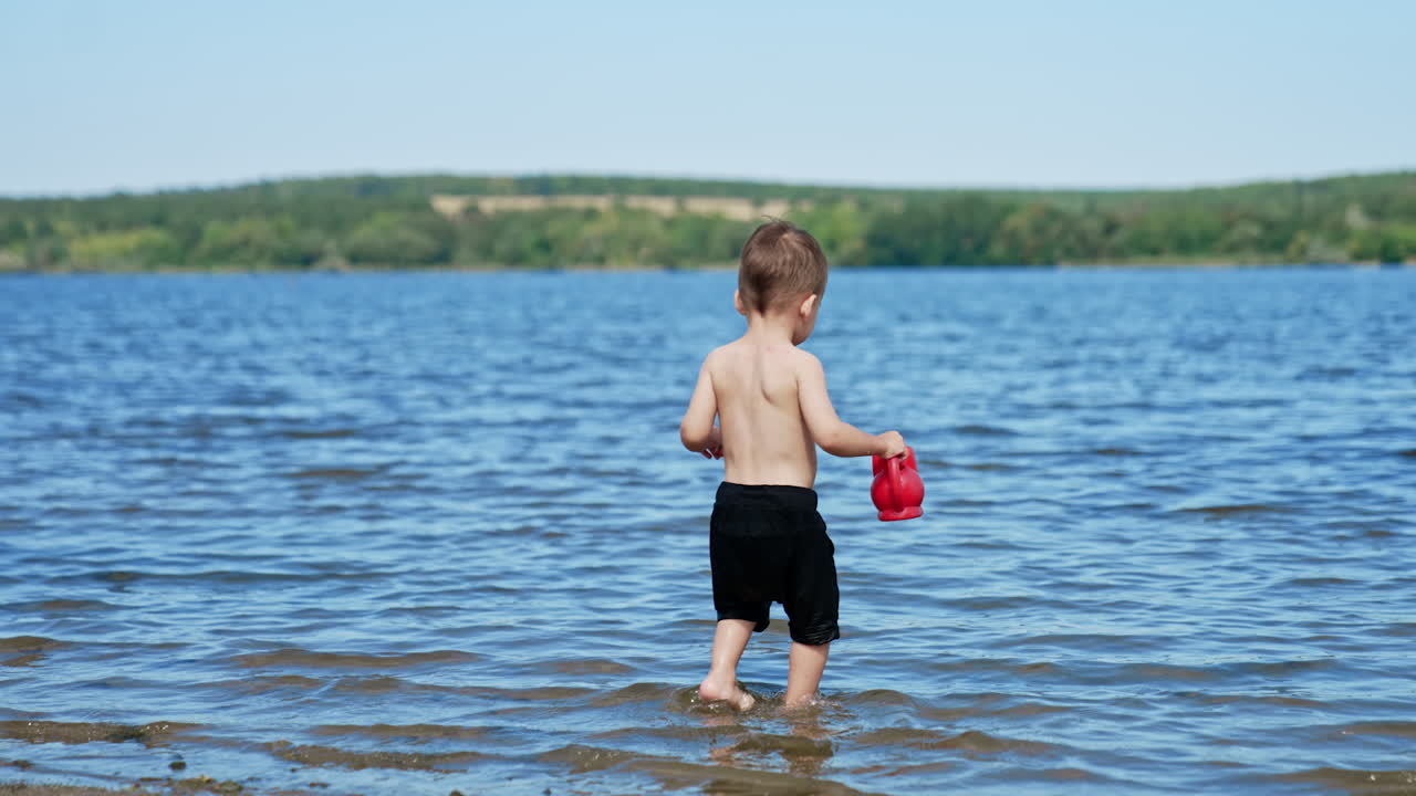 Child Playing with a Toy Teapot in the Lake