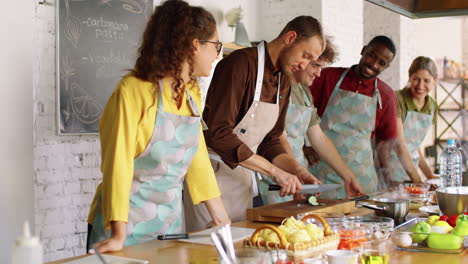 chef showing how to slice cucumber during cooking master class