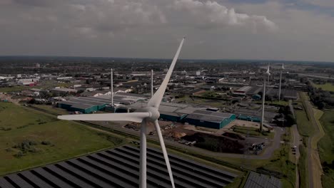 wind turbines, field of solar panels, biofuel and water recycling facility in dutch waterway infrastructure landscape