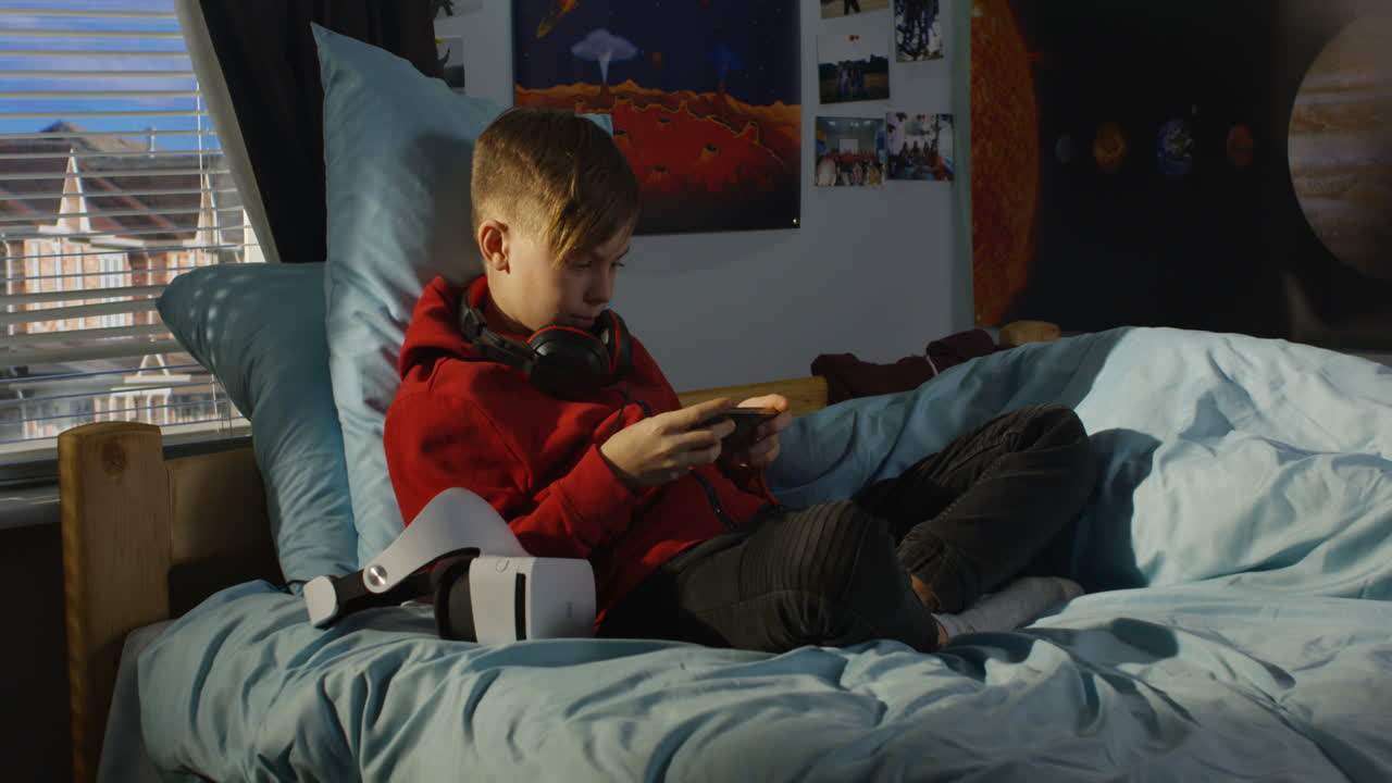Boy Playing Games in His Bedroom