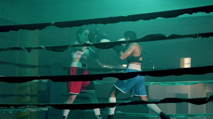 Due pugili donne caucasiche si allenano insieme in una palestra di boxe.