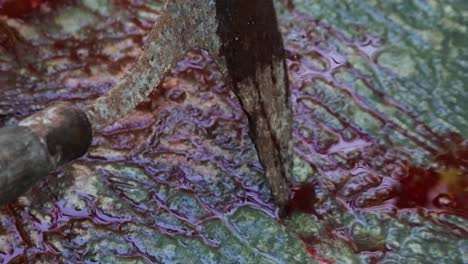 gruesome illustration of male hands holding bloodstained scythe