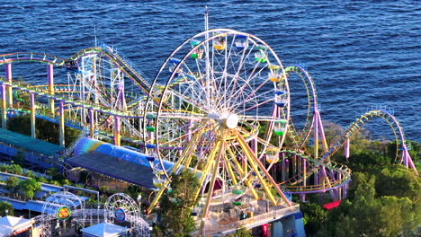 Orbiting-aerial-drone-tele-lens-shot-of-Ocean-Park-Ferris-wheel-with-ocean-in-the-background,-Hong-Kong