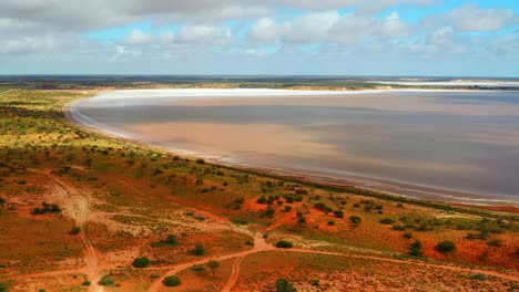 Vista-Aérea-Del-Lago-Tranquilo-Y-Terreno-Rojo-En-Australia