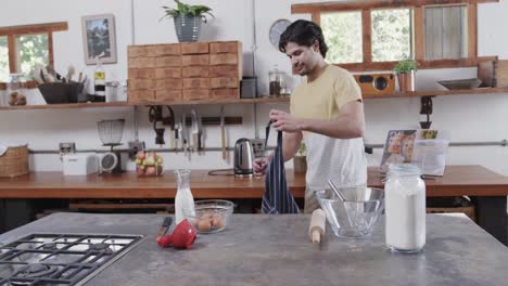 caucasian man wearing apron in kitchen, slow motion