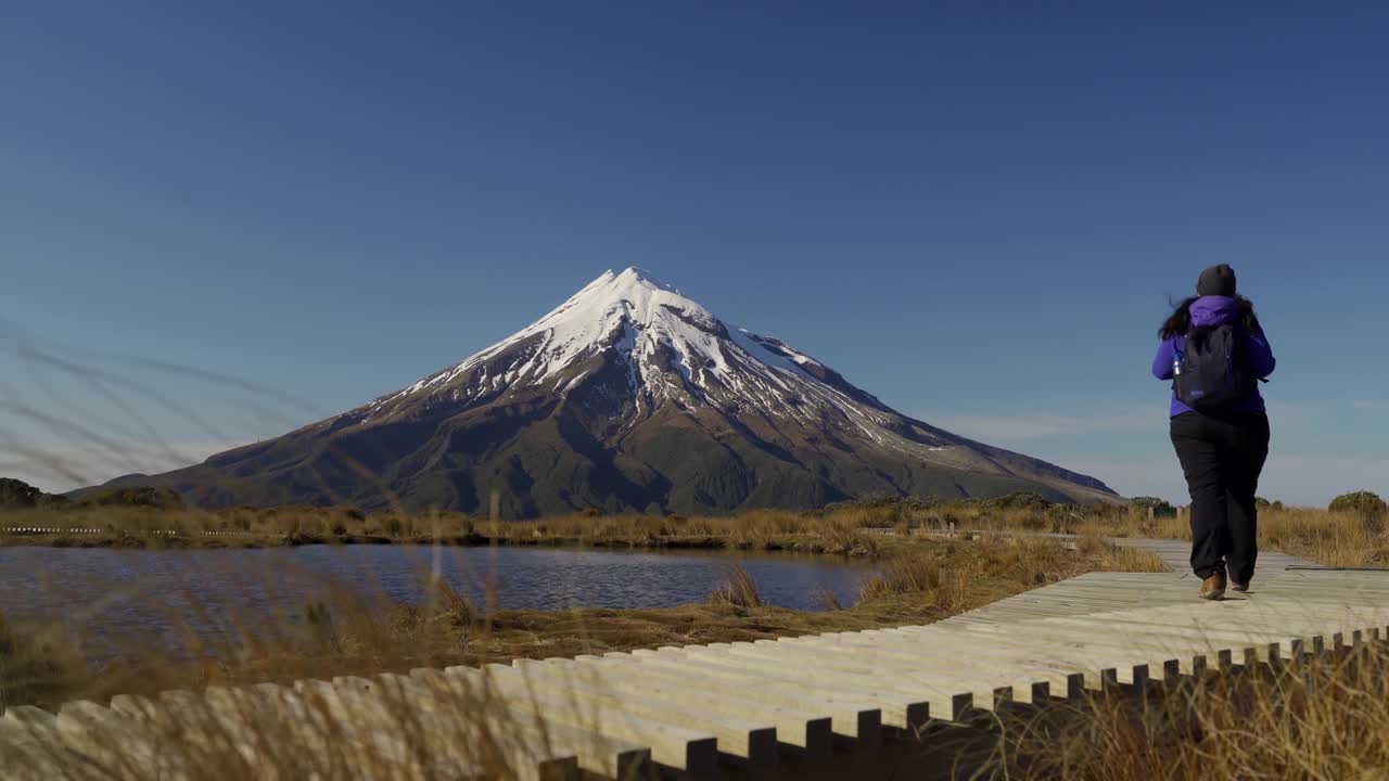 뉴질랜드 에그몬트 국립공원 타라나키 산의 푸아카이 산책로를 고 있는 여성
