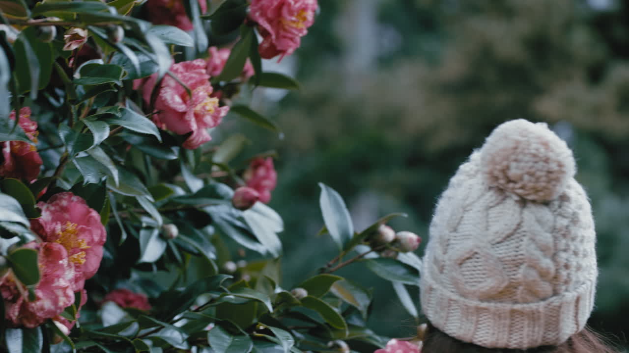 bellissima giovane donna che tocca un fiore rosa che guarda una ragazza spaventata sorpresa spavento nel parco del giardino fobia agli insetti